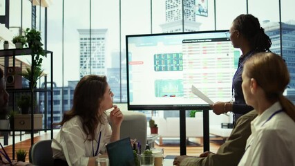 Employees team analyzing infographics to offer solutions for new project, looking to finish tasks before deadline. Enterprise coworkers attending problem solving conference in boardroom. Camera B.
