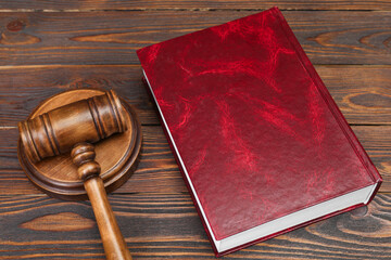 Book and judge's gavel on wooden table