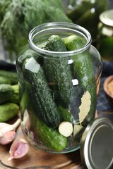 Making pickles. Fresh cucumbers and spices in jar on table, closeup