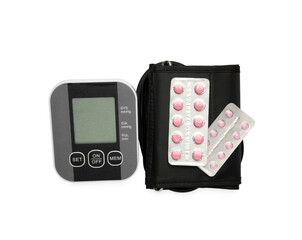 Blood pressure monitor and pills in blisters isolated on white, top view