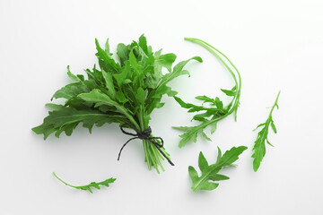 Fresh green arugula leaves on white background, flat lay