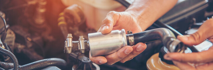 Banner Mechanic man hands repairing car shop. Man hands fixing Car machinery vehicle mechanical service. Panorama open vehicle hood checking up auto mobile. Car maintenance engineer with copy sapce