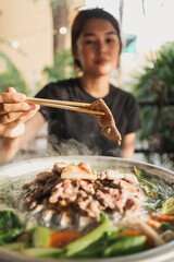 Happy asian woman enjoy her delicious Thai BBQ Buffet.