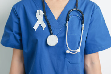 November Lung Cancer Awareness month and Stop Violence Against Women. Doctor with White ribbon in hospital. Healthcare and World Cancer day concept