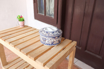 Traditional jar made from porcelain with decorative blue floral pattern on wooden table