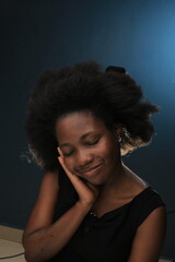 Headhoot of an African American Lady in a black dress smiling and she is more than pretty with natural black hair