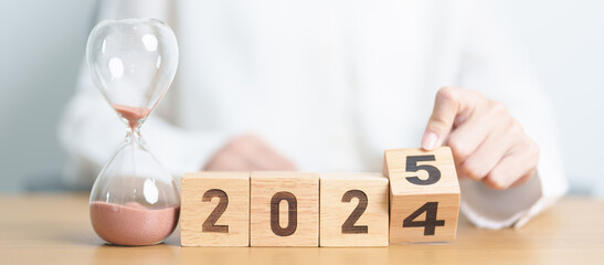 2024 end year to Happy New Year 2025 with hourglass on table. Resolution, time, plan, goal,...