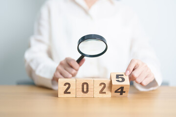 2024 end year to Happy New Year 2025 with magnifying glass and people. hiring, employee,...
