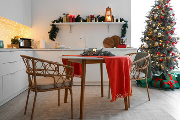 Interior of kitchen with counters, dining table and Christmas tree