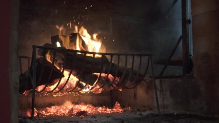 Close shot of the fire, an artisan preparing wood on the side of barbecue grill