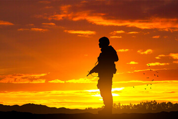Obraz premium Silhouette of soldier against the sunset. Military background