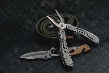 Folding knife with functional tool with tactical belt. Set of men's tools and accessories.