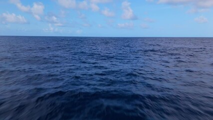 Aerial dolly over open ocean crystal clear blue waters