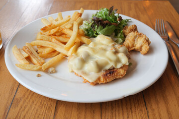 A Delicious and Appetizing Plate of Breaded Chicken Served with Crispy Fries and Fresh Salad