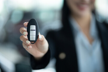Close Up Of Businesswoman's Hand Showing Car Key At Car Showroom