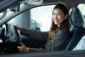 Portrait Of Smiling Woman Testing A New Car In Showroom