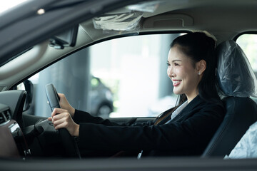 Smiling Woman Testing A New Car In Showroom
