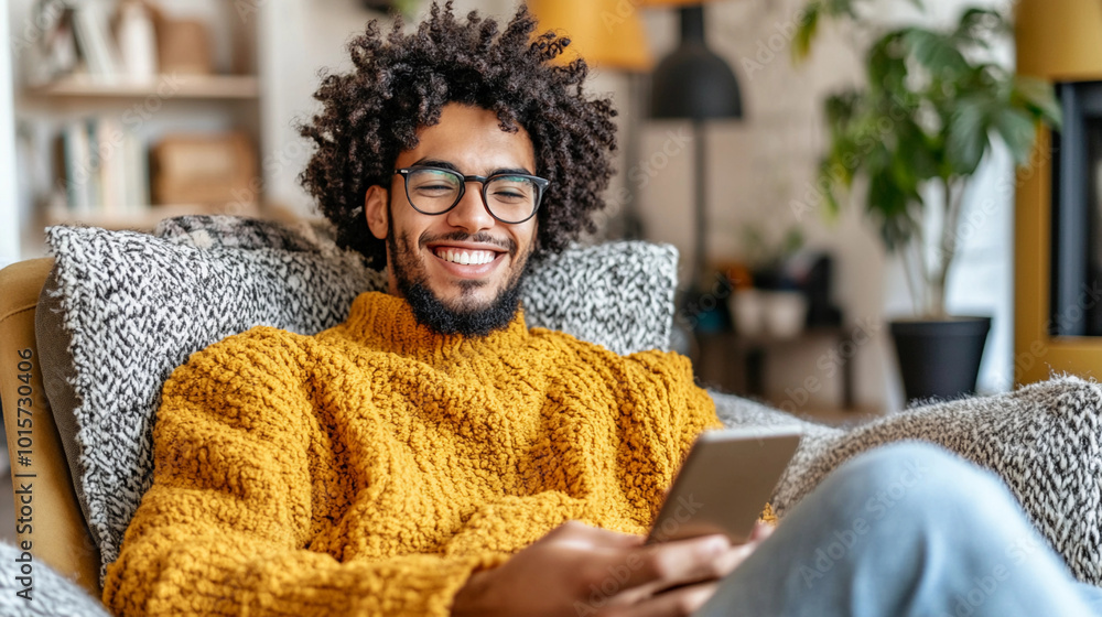 Poster a man with a beard and glasses is sitting in a chair with a tablet in his hand. he is smiling and he