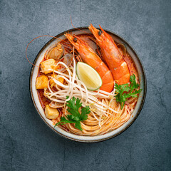 Laksa, Malaysian noodle soup on a dark concrete background, top view