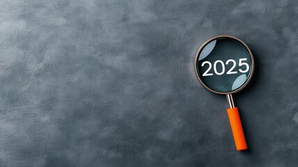 A magnifying glass focuses on the year 2025 against a textured gray background, symbolizing future insights or forecasts.