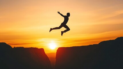 Silhouette of a Man Jumping Over a Canyon at Sunset