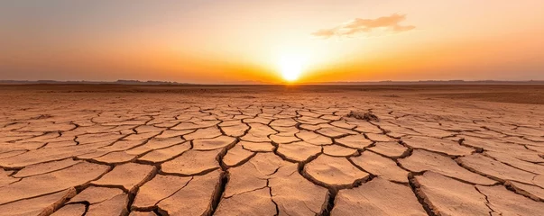 A breathtaking sunset over a cracked desert landscape, showcasing the beauty of nature's resilience and the starkness of dry earth.