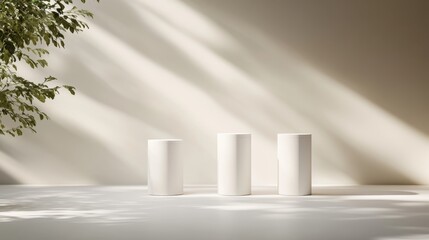 A modern arrangement of three white pedestals of varying heights sits on a clean white surface, casting gentle shadows, perfect for showcasing products or designs
