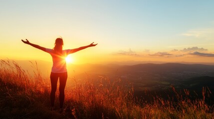 Standing on a hilltop at sunrise, a woman with her arms spread wide welcomes the new day. The silhouette captures the rays of light, embodying energy and optimism