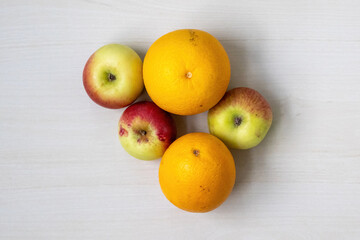 Fresh fruits, apples and sweet orange on a light wooden surface. Healthy diet. Top view.