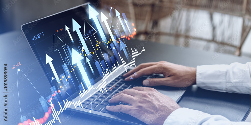 Poster hands typing on a laptop displaying upward financial charts and arrows.