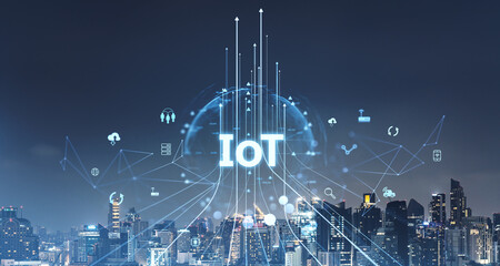 IoT concept with digital connections and icons over cityscape at night.