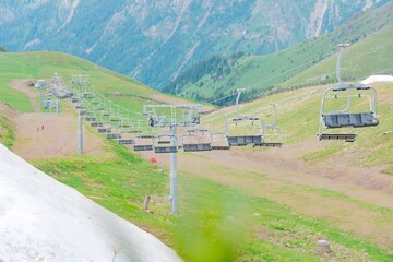 Cable car with chairs in the green valley