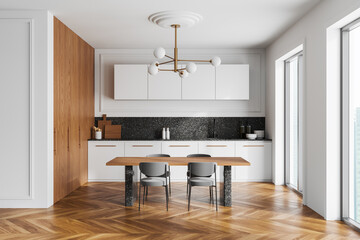 Home kitchen interior with eating table, cooking cabinet and panoramic window