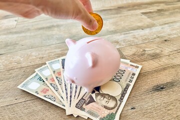 貯金箱にお金を入れる手