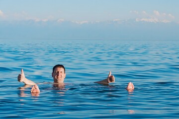 A young man swims in the salty sea