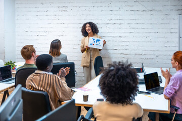 Colleagues applauding to a coworker during presentation of a project