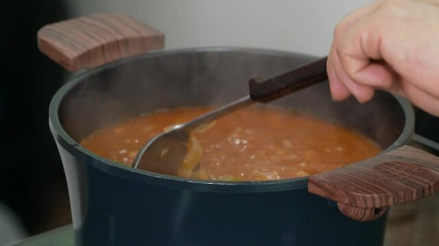 냄비에서 끓는 애호박 김치찌개를 국자로 푸는 모습