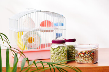 A colorful small animal habitat with tubes, food containers, and plants in a bright indoor space