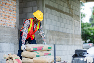 Worker is unloading the bags of cement an apartment is under construction, remodeling, renovation,...