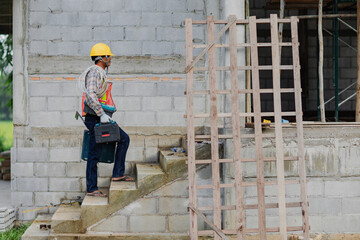 Worker with tool. Builder handyman with construction tools. House renovation background. Male worker with tool bag near door at home