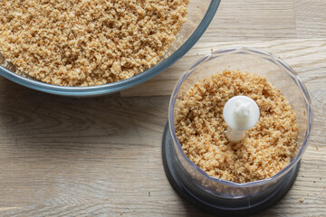 Wholemeal brown breadcrumbs in a mini electric food chopper. Food preparation concept