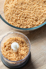 Wholemeal brown breadcrumbs in a mini electric food chopper. Food preparation concept