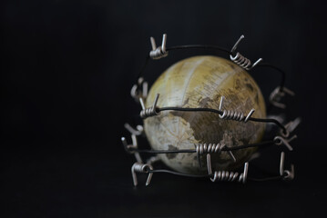 War barbed wire (razor wire, Concertina wire;) surround on the blur globe. outbreak of war and war effect concept such as war victims, macroeconomic effect, political decisions, economic,