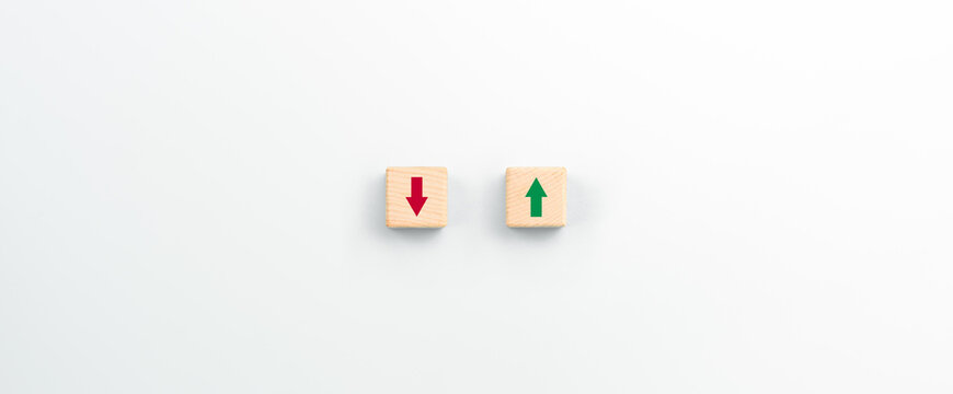 Up and down arrows on wooden cubes. Growth or loss. Going up or down. Economic growth or business investments.
