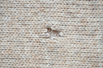 hole in a brown pastel jumper, hole in a tan woollen jumper,	knitted sweater beige texture