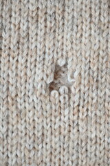 hole in a brown pastel jumper, hole in a tan woollen jumper,	knitted sweater beige texture