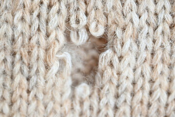 hole in a brown pastel jumper, hole in a tan woollen jumper,	knitted sweater beige texture