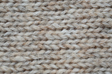 The texture of fabric thick beige sweater close-up. Knitted texture background