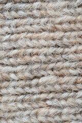 The texture of fabric thick beige sweater close-up. Knitted texture background