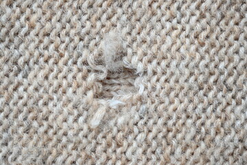 hole in a brown pastel jumper, hole in a tan woollen jumper,	knitted sweater beige texture